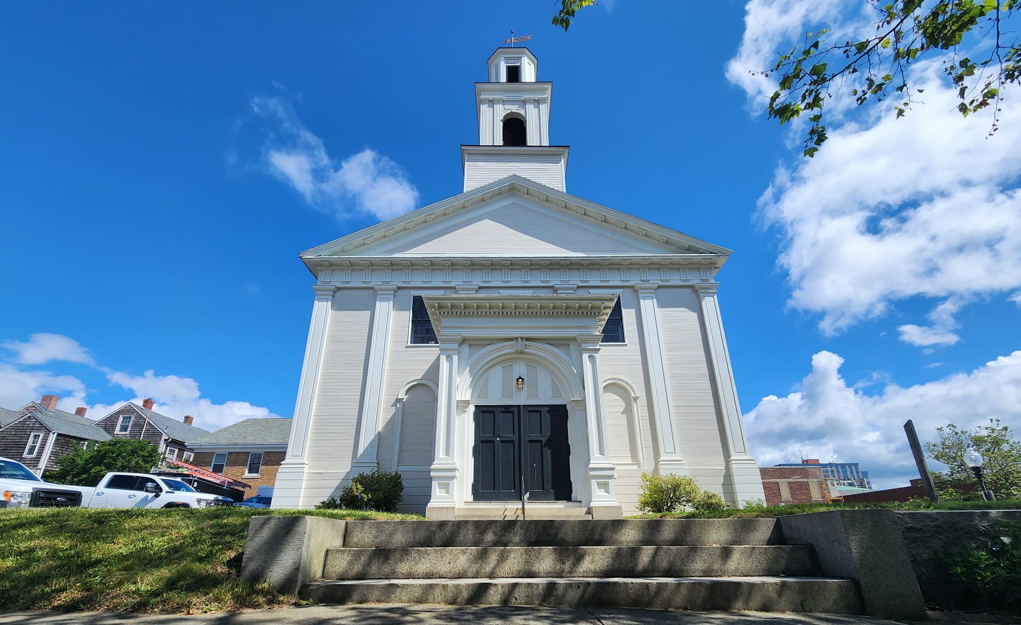 STEEPLE Front view of Steeple Playhouse showing dark green front doors and the towering steeple above them.